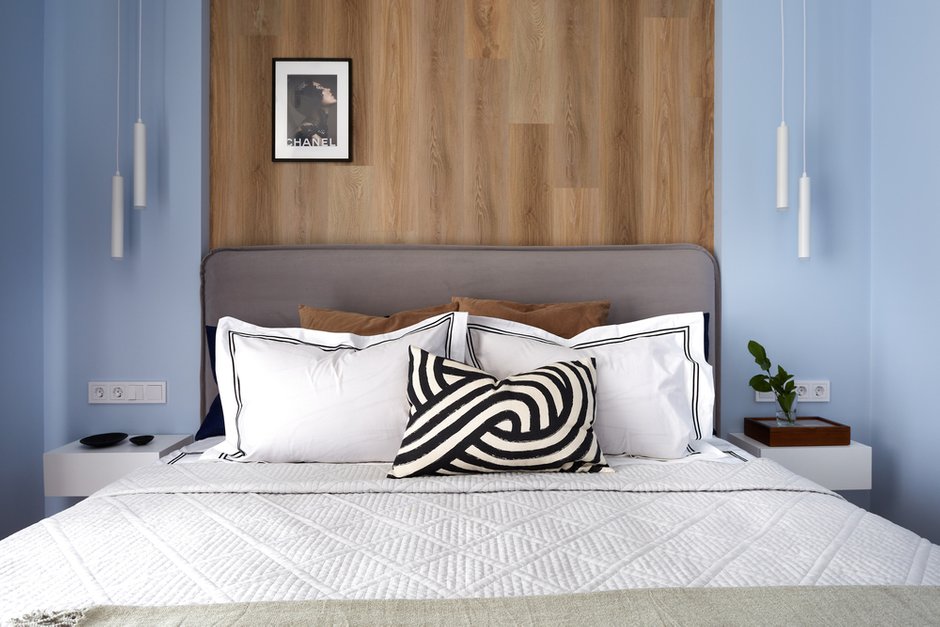 В спальне за изголовьем применили кварц-виниловый декор. Он абсолютно «неубиваем», не боится влаги, легко наклеивается и отлично имитирует дерево. 