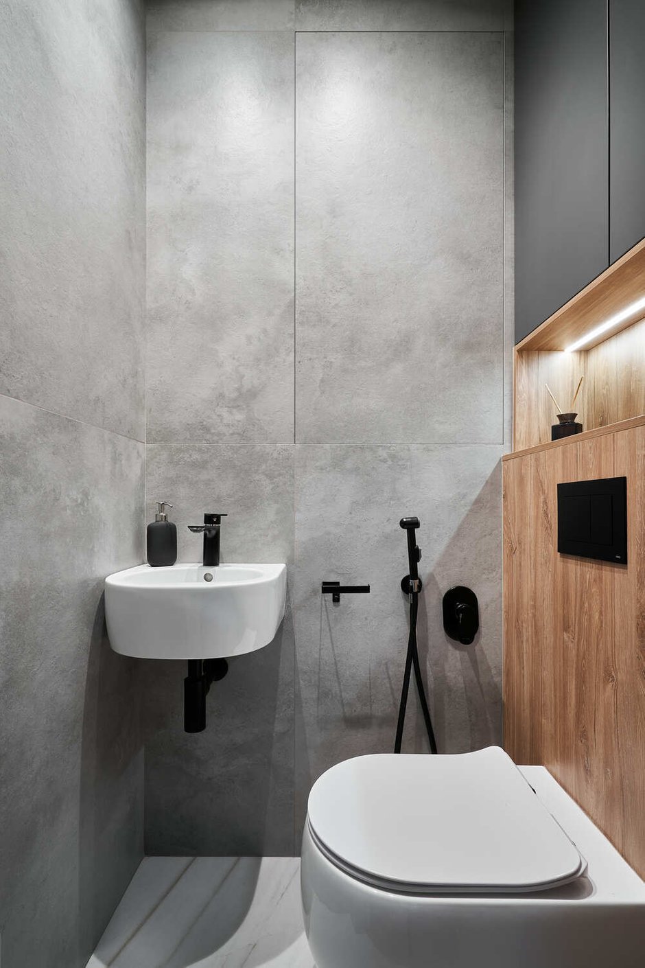 В санузле поместилась маленькая раковина для мытья рук и шкафчик над инсталляцией.