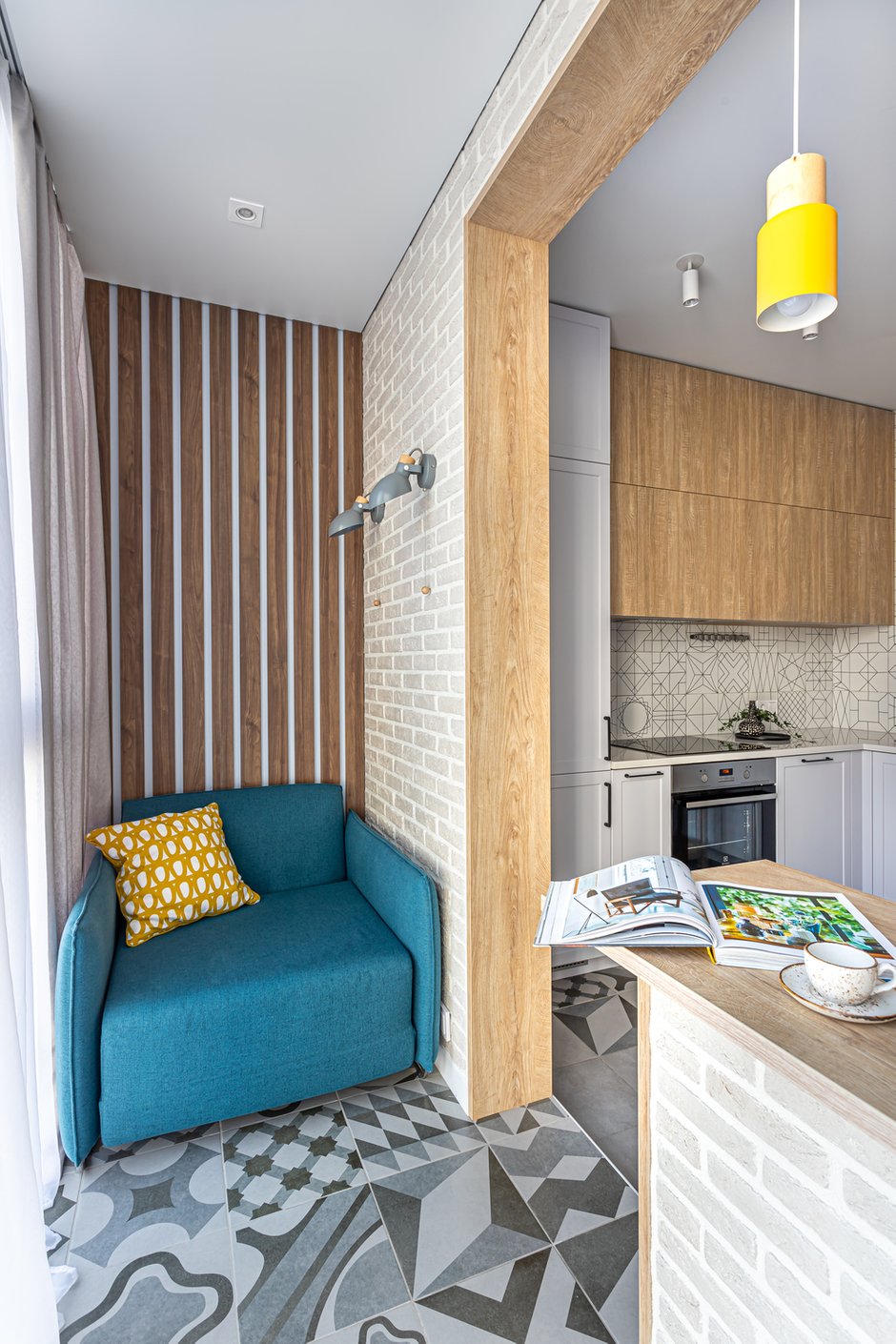 Нужно было обустроить место уединения для главы семьи, получилось отдать целую лоджию, присоединенную к кухне. Здесь разместили раскладывающееся кресло с функциональным светом, журнальный столик и барную стойку для приятных посиделок.