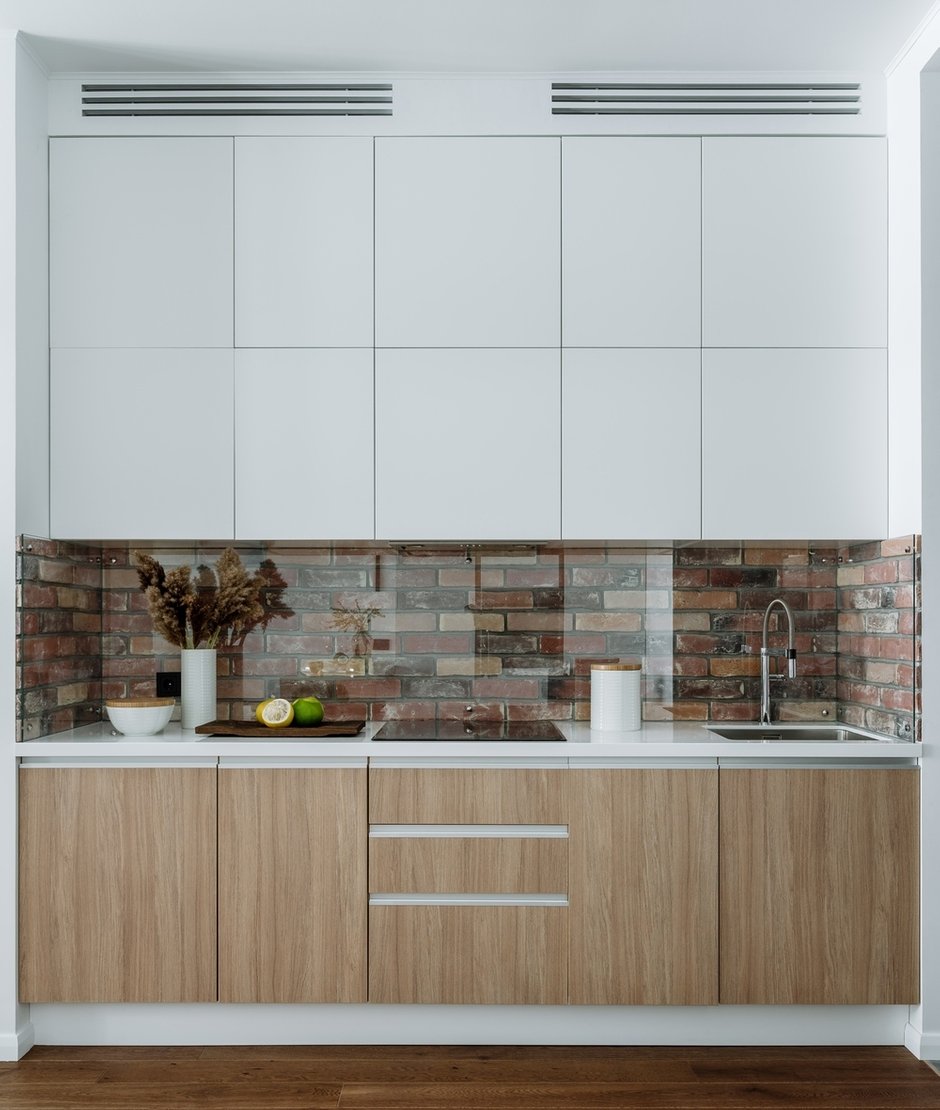 Фартук облицован клинкером и закрыт стеклянным скинали, который легко протирать. Клинкер за стеклом создает эффект сохранения участка фасада здания. Музейный прием, который аккуратно проводит аналогию с названием жилого комплекса и районом Трайбека (TriBeCa) в Нью-Йорке со зданиями из кирпича.