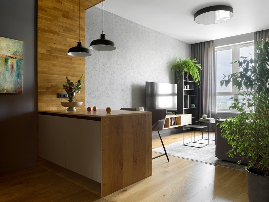 Особенностью квартиры стало то, что ее удалось полностью решить в комплементарной цветовой гармонии, или диаде: серый цвет стен и отделок с легким фиолетово-синим подтоном дополняется элементами в отделке из дерева с желто-оранжевым подтоном.