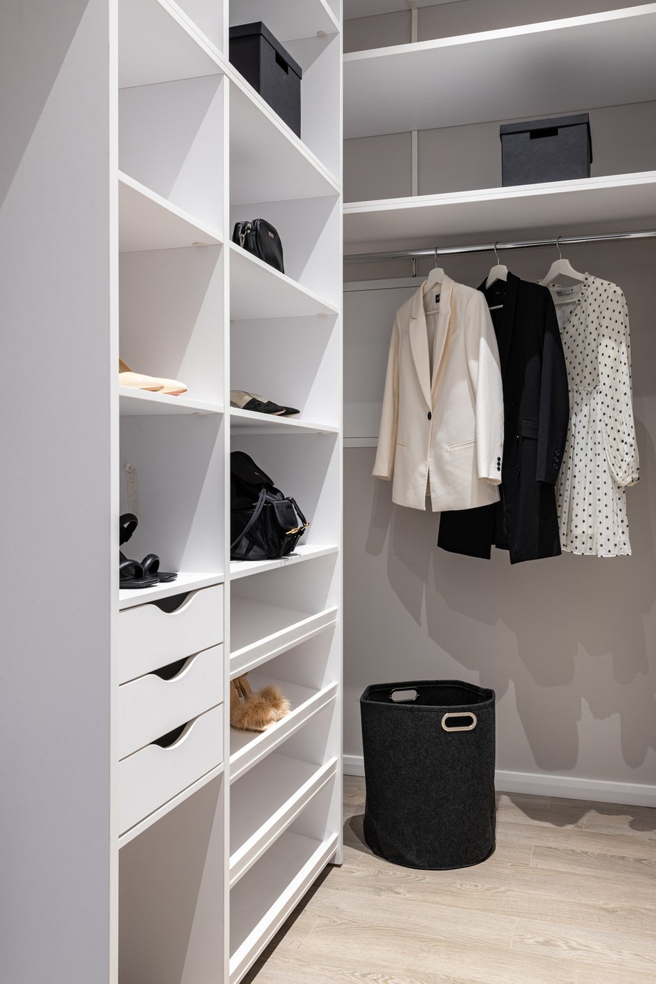 Еще одно место для хранения в квартире — это отдельная гардеробная при входе. Функцию хранения вещей выполняет открытый угловой шкаф. В нем предусмотрены штанга для верхних вещей, которые, например, не нужны в текущем сезоне, обувница, множество полок и несколько выдвижных ящиков.