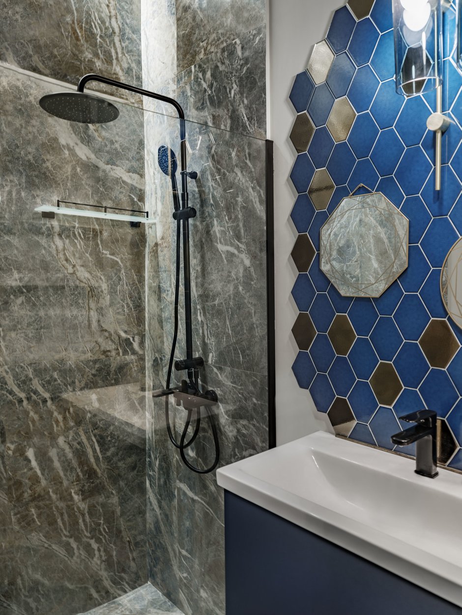 В санузле часть стен полностью выложили крупногабаритным керамогранитом. Смотрится монументально и одновременно лаконично. Придает интерьеру вид респектабельного и дорогого пространства.