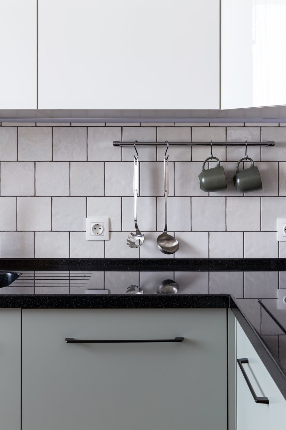 Кухонный гарнитур дополнили контрастной черной фурнитурой, которая делает пространство более стильным и ярким.