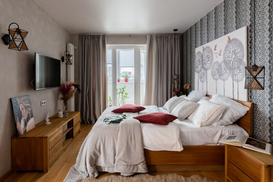Акцентом в зоне спальни выбрали контрастные обои с геометрическим рисунком, в поддержку им подобрали ткани на шторы с такой же геометрией. Пестрые элементы уравновесили однотонными стенами.