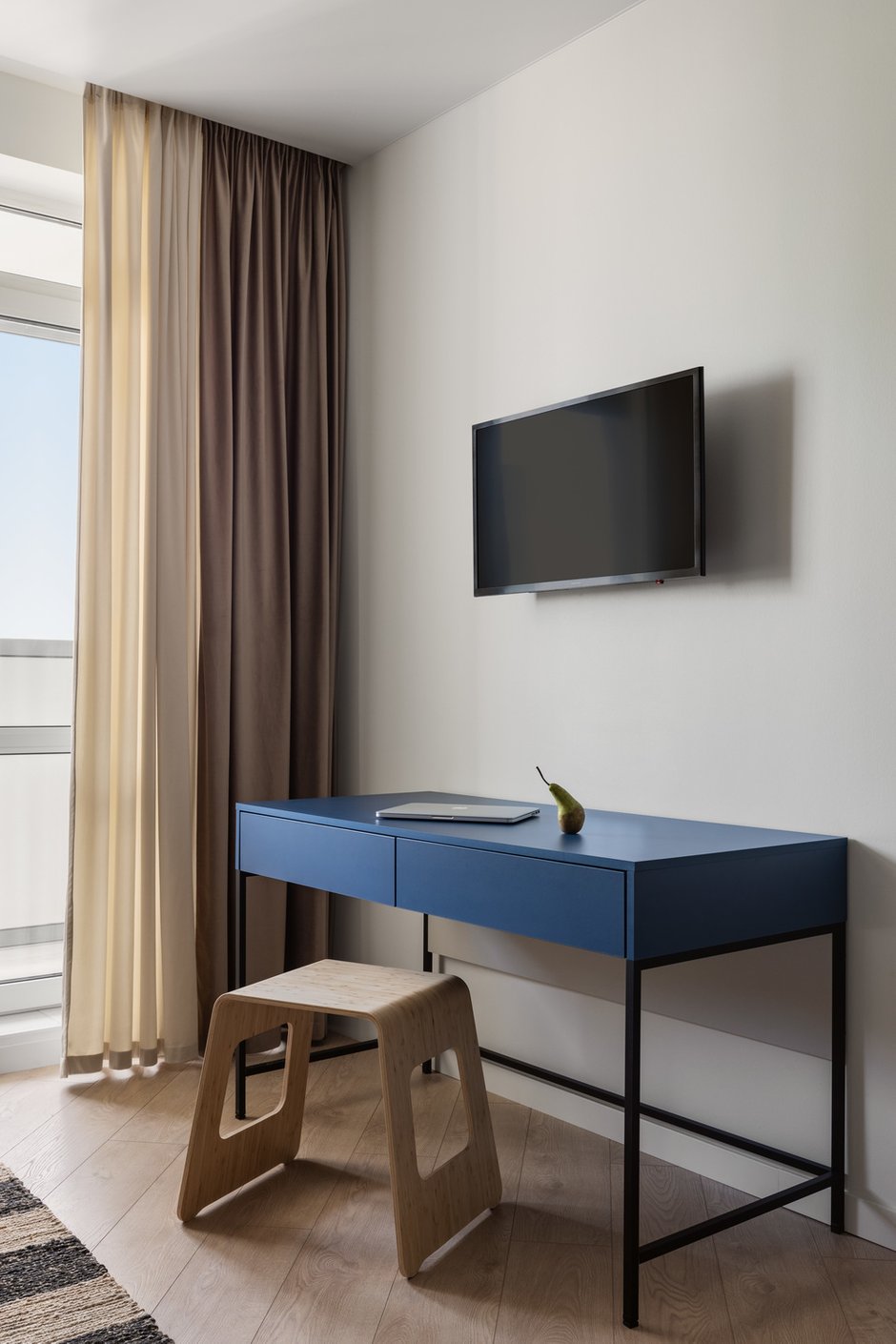 Помимо обеденной группы в квартире-студии удалось расположить письменный стол, выполненный на заказ в синем цвете в поддержку кухне-нише.