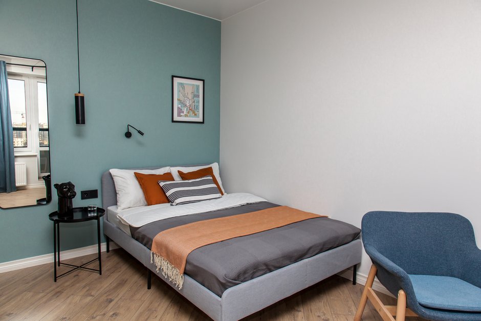 Дизайнер выбрала акцентные черные элементы: прикроватный столик, рамы, зеркало и светильники. 