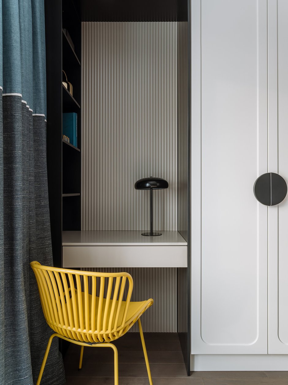 На стене за столом использовали рельефные панели: они добавляют глубины и перекликаются с вертикальными полосками на спинке стула.