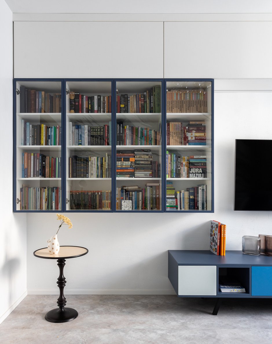 В гостиной дизайнер придумала систему шкафов для хранения книг. Антресоли в цвет стен тоже являются хорошим местом хранения. Изготовлены индивидуально на местном производстве.
