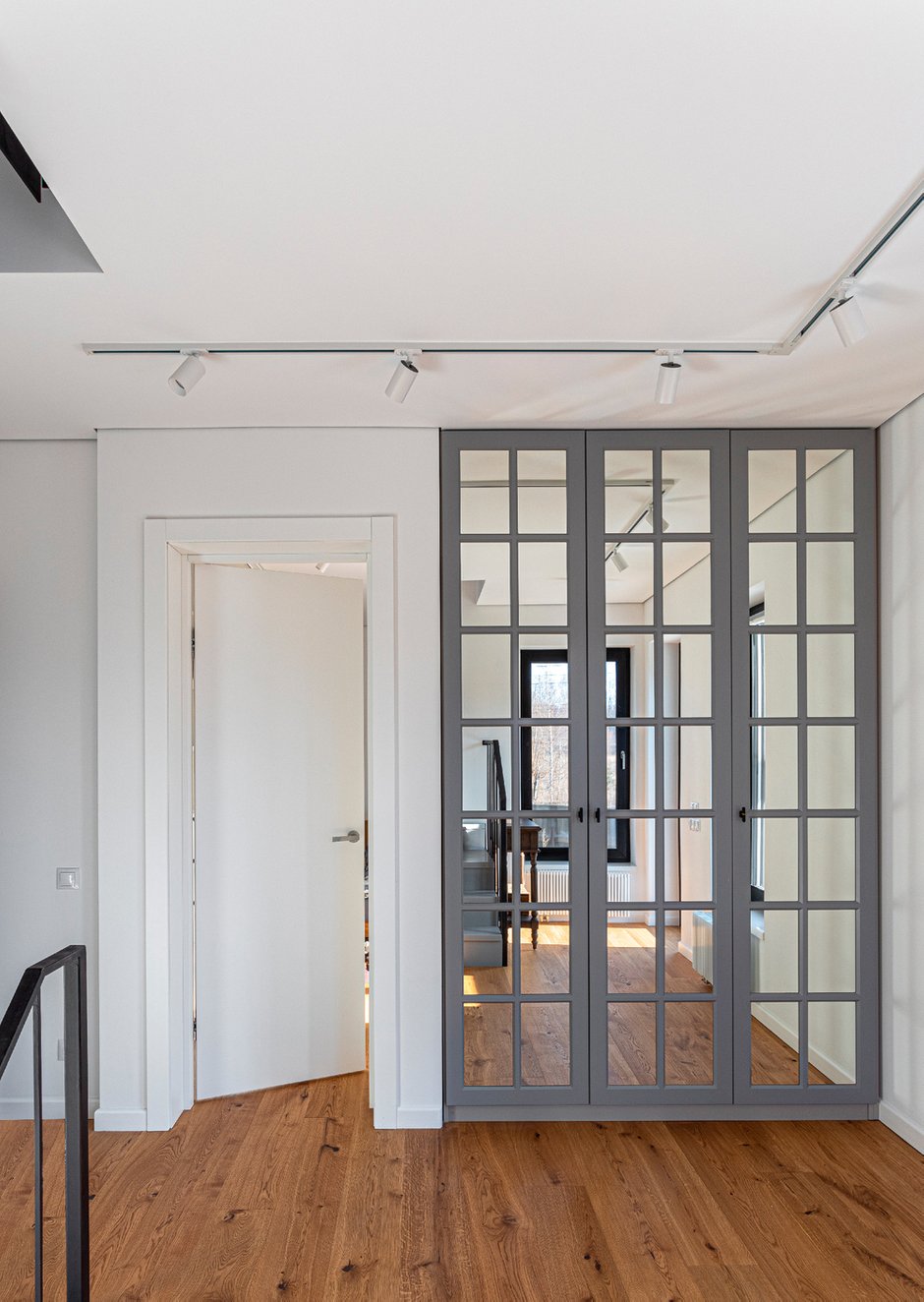 В прихожей спроектировали встроенный зеркальный шкаф, остальные системы хранения открытые и максимально воздушные — библиотека и стеллажи в мансарде, открытые полки на кухне и в ванной.