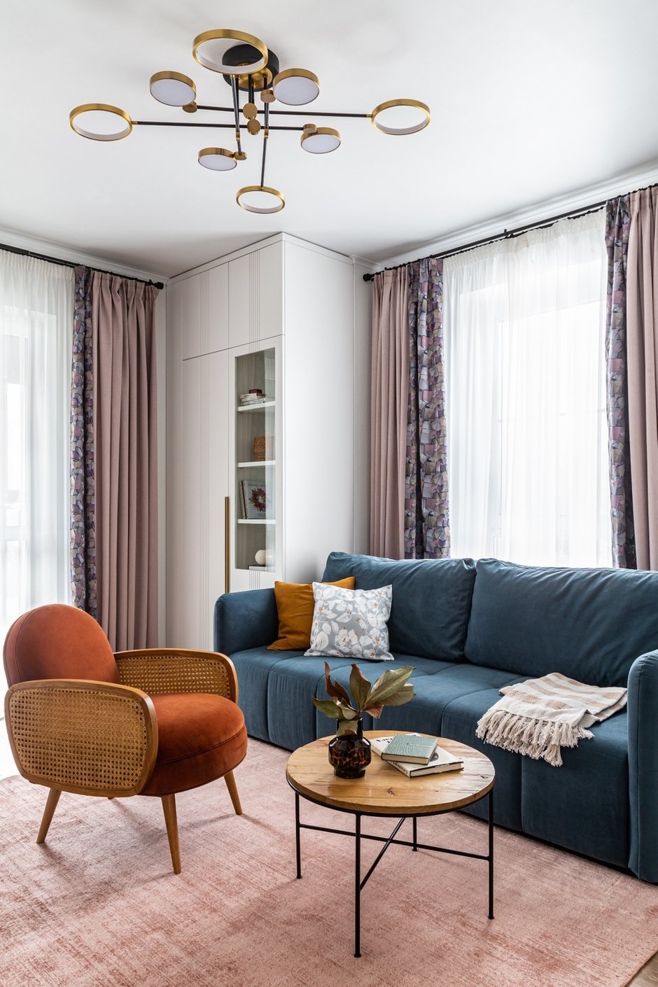 В гостиной пришлось переносить часть коммуникаций, штробить стены. Так появились шкафы с задними стенками и панель с фрезеровкой, которая перекликается с фасадами корпусной мебели.