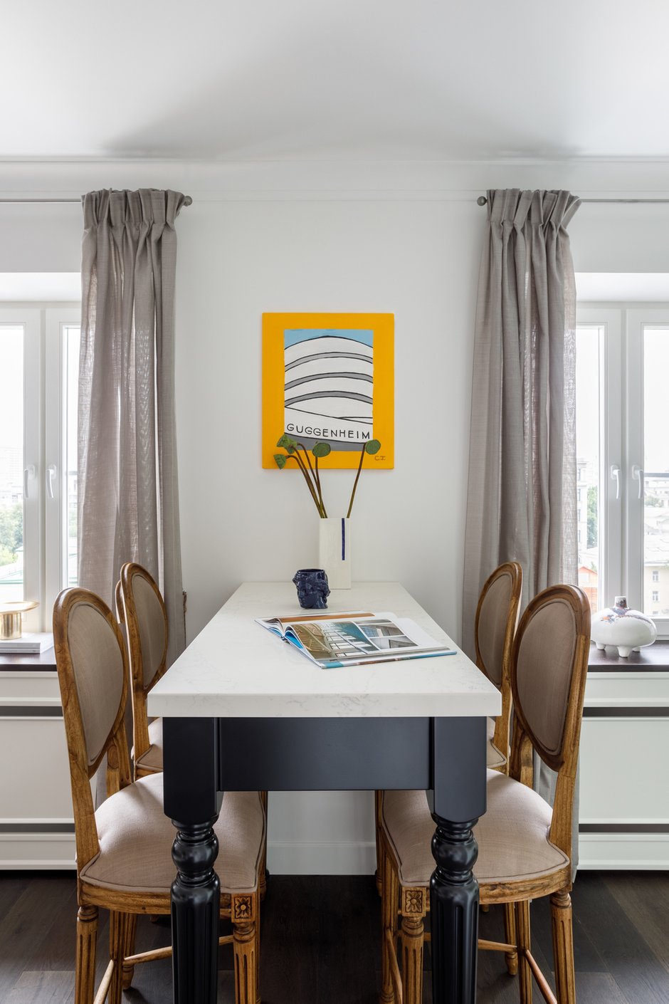 Барная стойка с фигурными черными ножками и столешницей из камня сделана на заказ. Люстры на кухне и в зоне гостиной, бра в простенке у окон довольно необычные — они достались заказчице по наследству.