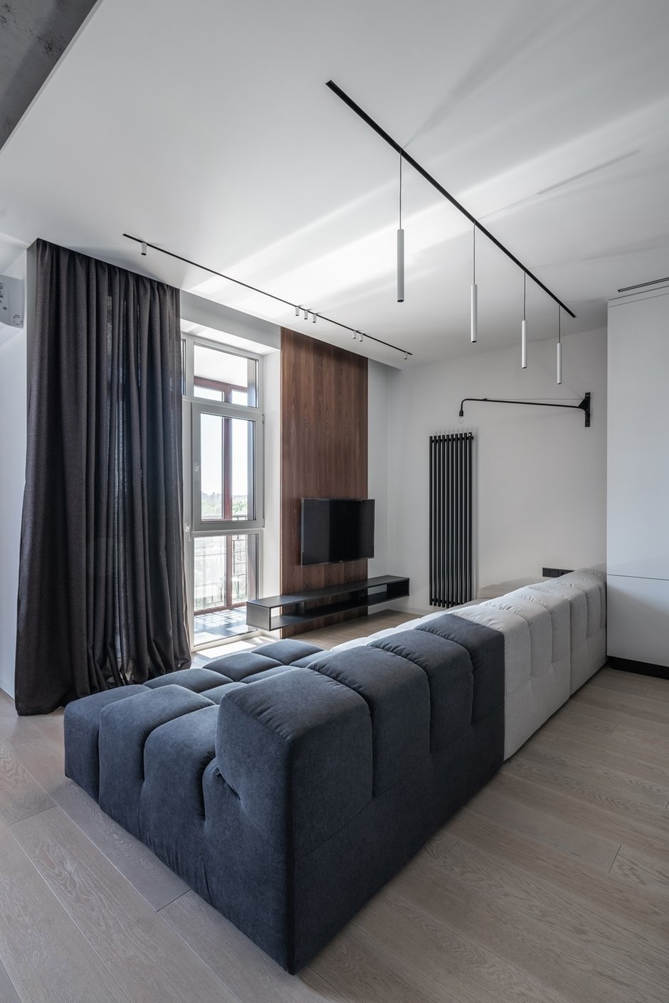 Не обошлось в квартире из без брендовых «точек притяжения». Одна из таких — диван Interia, расположенный вдоль всей зоны гостиной. Минималистичный дизайн, стык контрастных цветов — все его черты повторяют визуальную концепцию квартиры в целом.