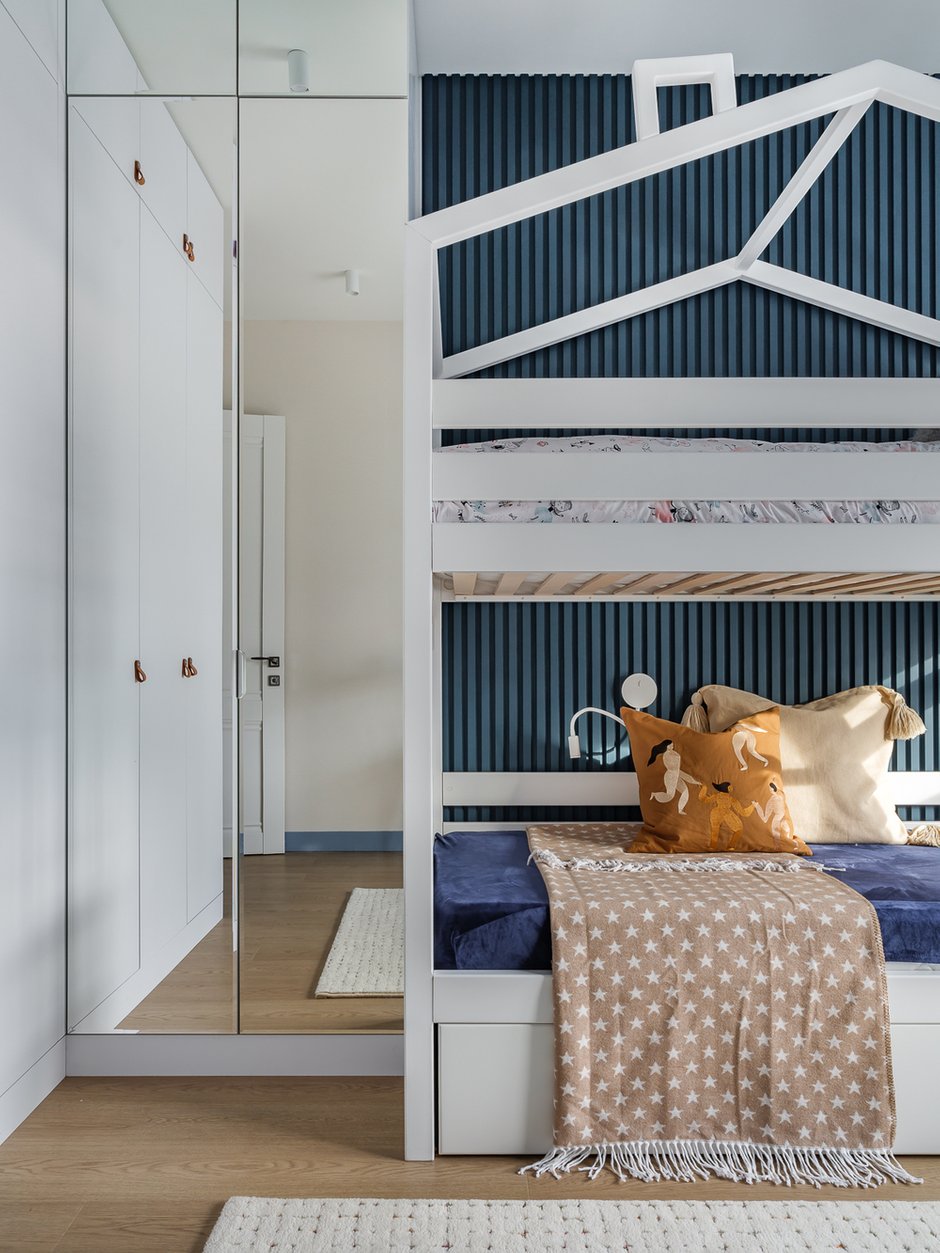 Комната принадлежит одной девочке. Идея кровати с двумя ярусами предполагает на первом этаже организовать место для игры, вешать занавеси и шатры, организовывать домик в домике.
