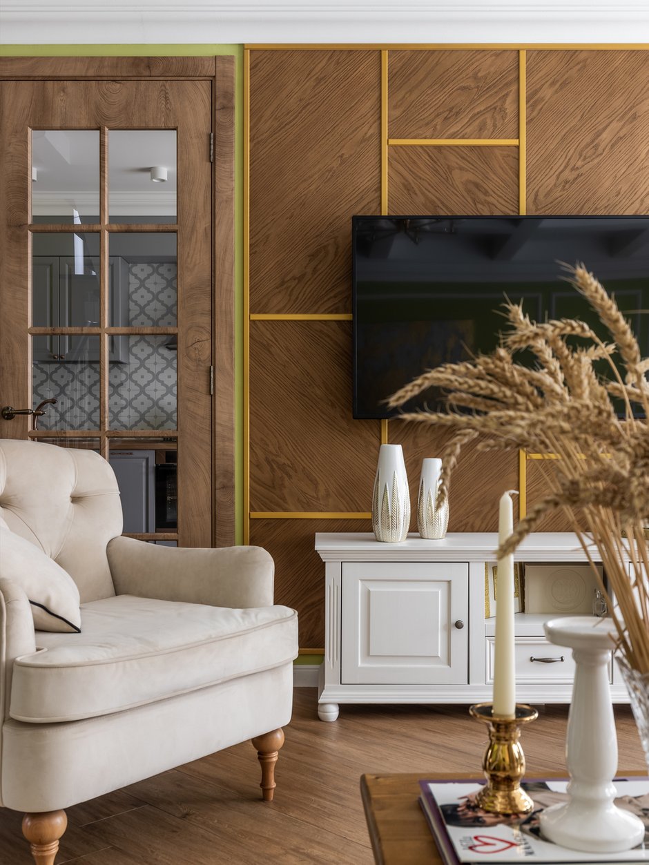 ТВ-зону оформили панелями из шпона с латунным профилем.