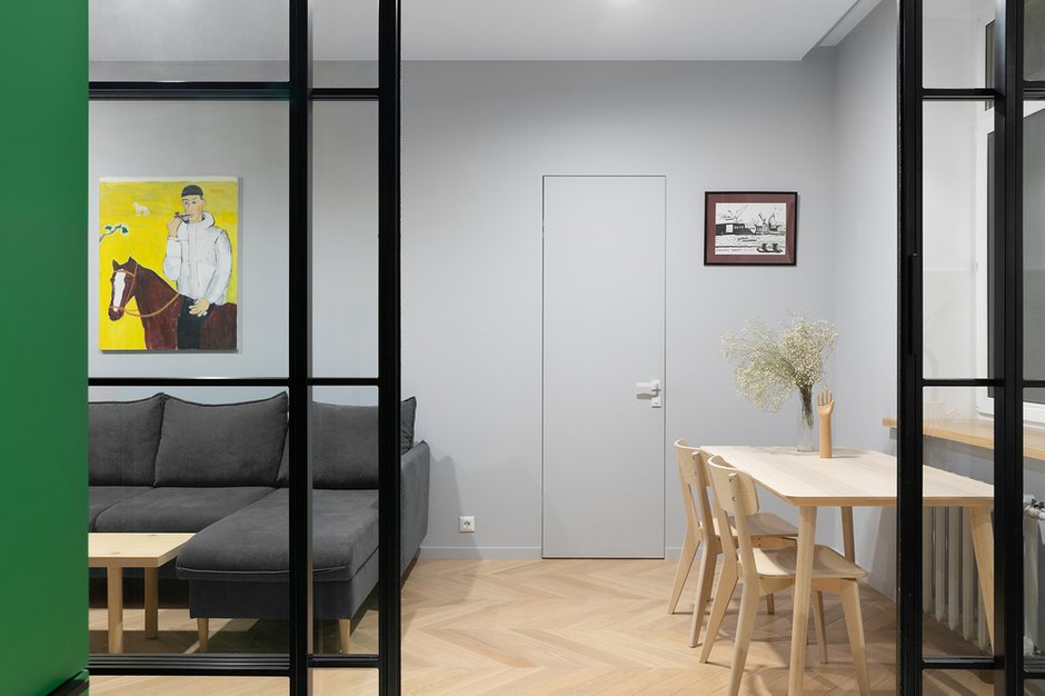 Было использовано минимальное количество отделочных материалов — керамогранит, паркет и серый нейтральный фон декоративной штукатурки, чтобы дополнительно визуально объединить пространство в небольшой по габаритам квартире. 