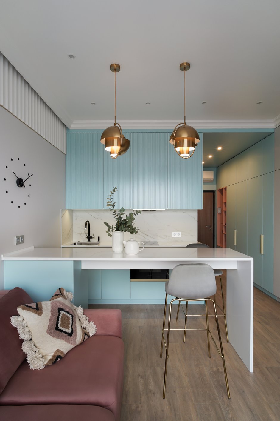 Вся мебель в этой квартире изготавливалась на заказ по проекту дизайнера. В гарнитуре предусмотрена встроенная ПМ на 45 см, варочная панель на две конфорки, над ней встроенная вытяжка, духовой шкаф с функцией СВЧ, встроенный холодильник. Верхние шкафы до потолка. Хранение ложек и вилок спрятано в острове.