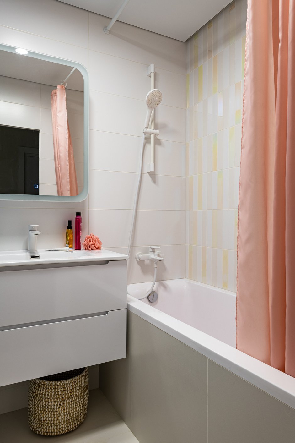 В ванной прослеживается такая же идея, как и во всей квартире: светлые стены и яркие акценты, здесь это голубой короб с коммуникациями и голографическая плитка над ванной.