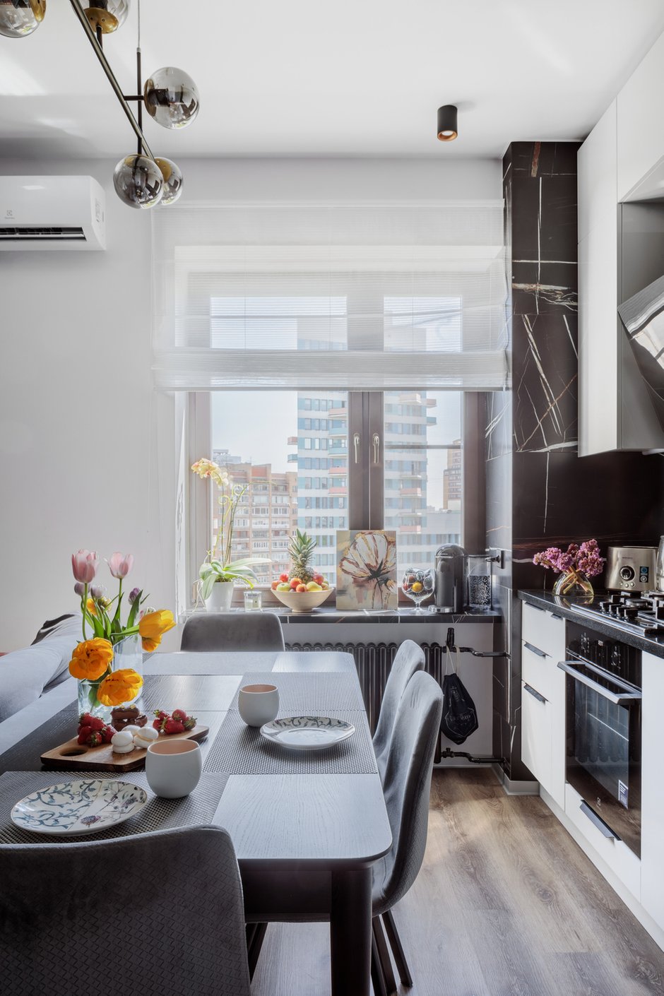 В кухне подоконник выполнен из керамогранита — на самом деле это лестничная ступень. Керамогранит дальше идет по порталу окна и по стене за кухней. 