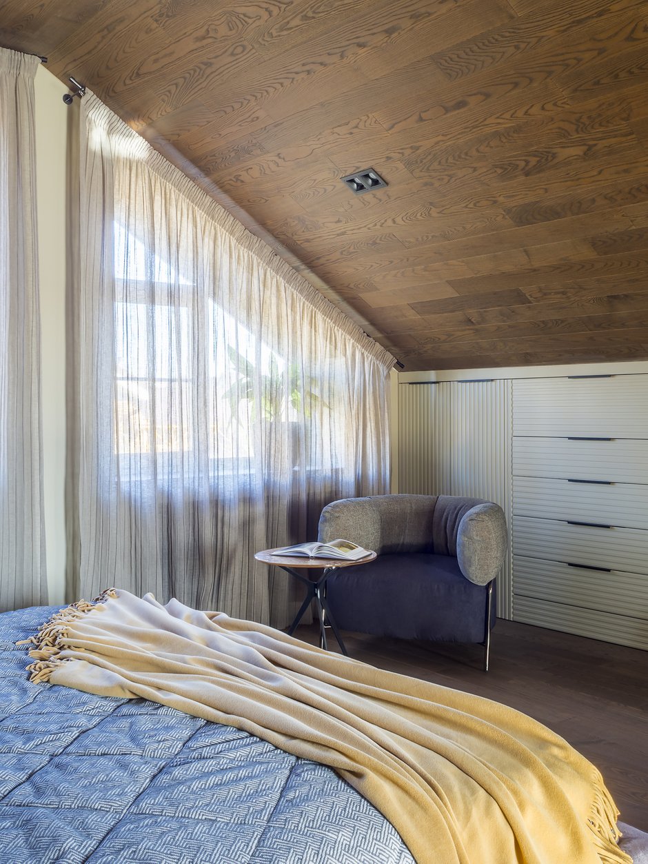 Хранение в спальне размещено в шкафах и комодах, встроенных вдоль скошенной стены.