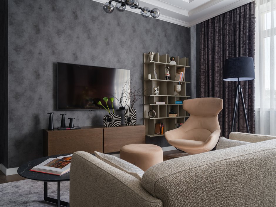 В гостиной-столовой стеллажи расположили на стене таким образом, что они зрительно удлиняют потолки и делают комнату пропорционально правильнее.