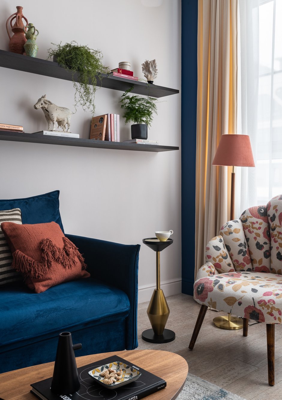 На окне в гостиной висят совершенно простые шторы в цвет светлых стен. Но стену за ними покрасили в насыщенный синий оттенок в тон дивану. И если шторы немного отодвинуть от углов, получается очень красивый эффект, как будто шторы с кантом.