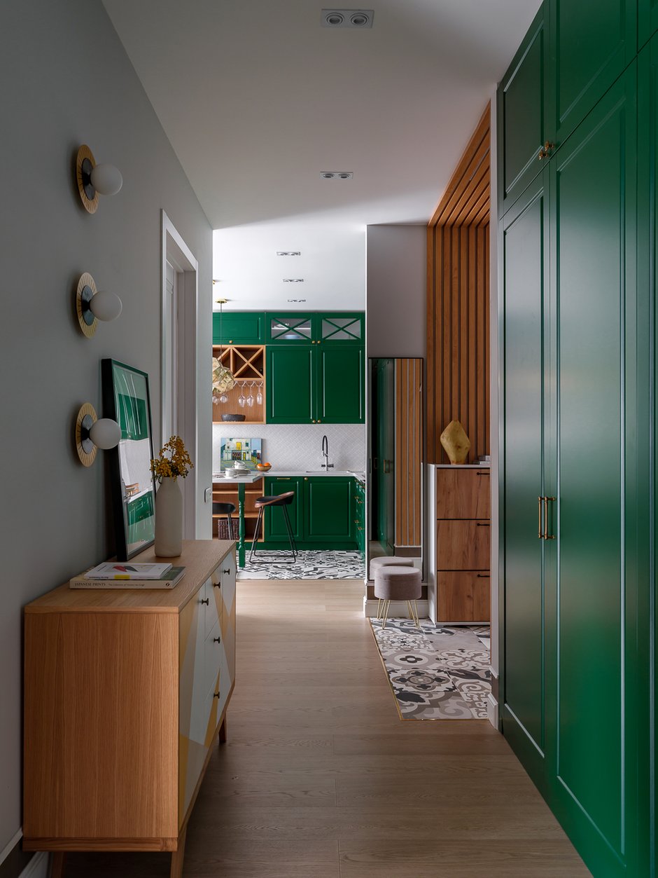 Заказчица мечтала о красивом месте в квартире, где можно создавать настроение декором и менять картины, выставлять цветы и декоративные аксессуары. Так появился комод между мастер-спальней и детской комнатой, с композицией из трех бра и картиной «Маргарита».