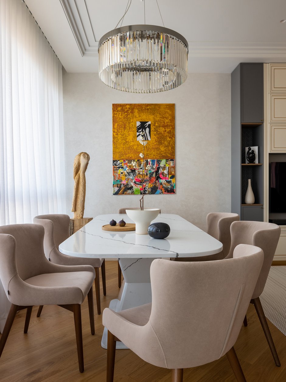 Строгость гостиной контрастирует с теплыми и эффектными декорами кухни. 