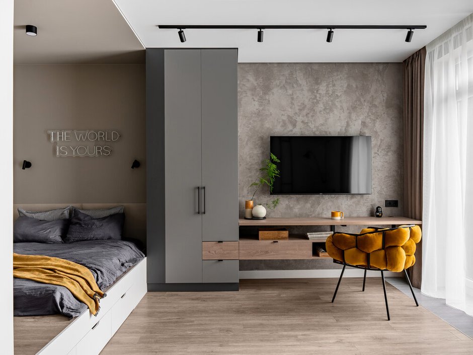 Отделка в ТВ-зоне выполнена декоративной штукатуркой под бетон и подчеркнута потолочной подсветкой.