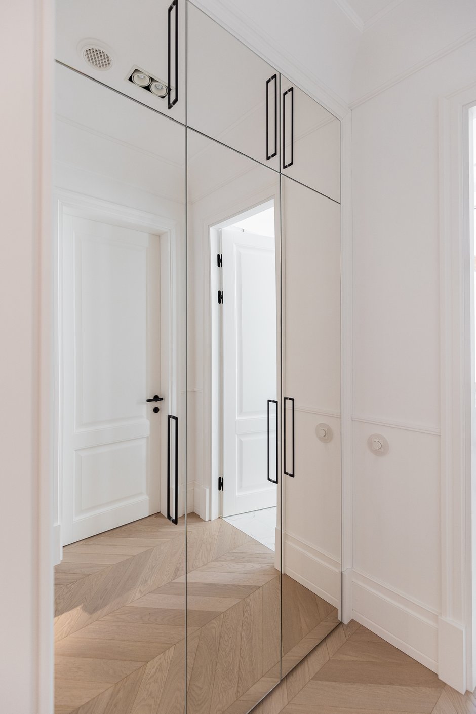 Гостевую гардеробную выполнили с зеркальными фасадами, чтобы расширить пространство. 